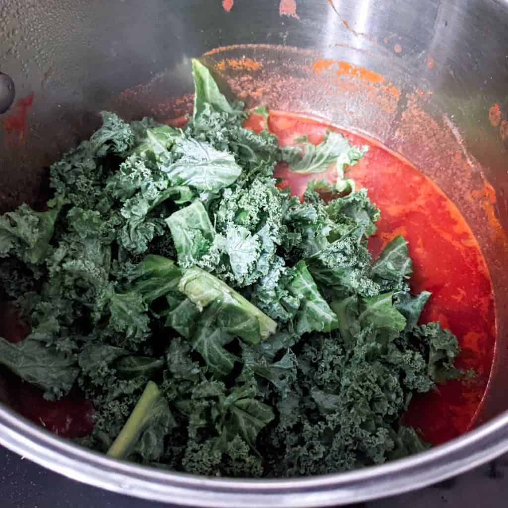photo of adding fresh kale to tuscan soup